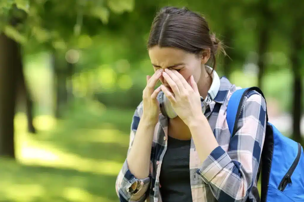 Woman outside suffering from eye allergies